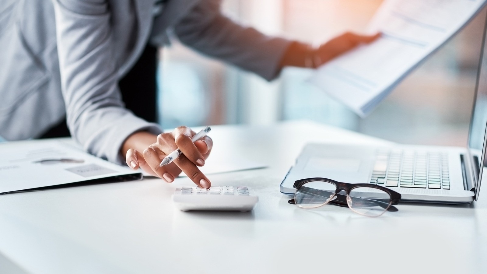 Une femme utilisant une calculatrice et un ordinateur